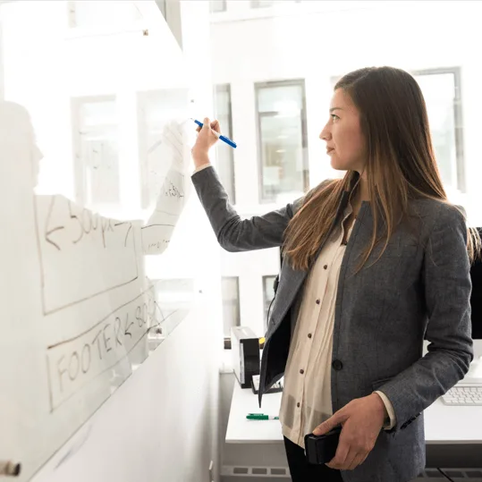 Dozentin plant eine Vorlesung an einem Whiteboard